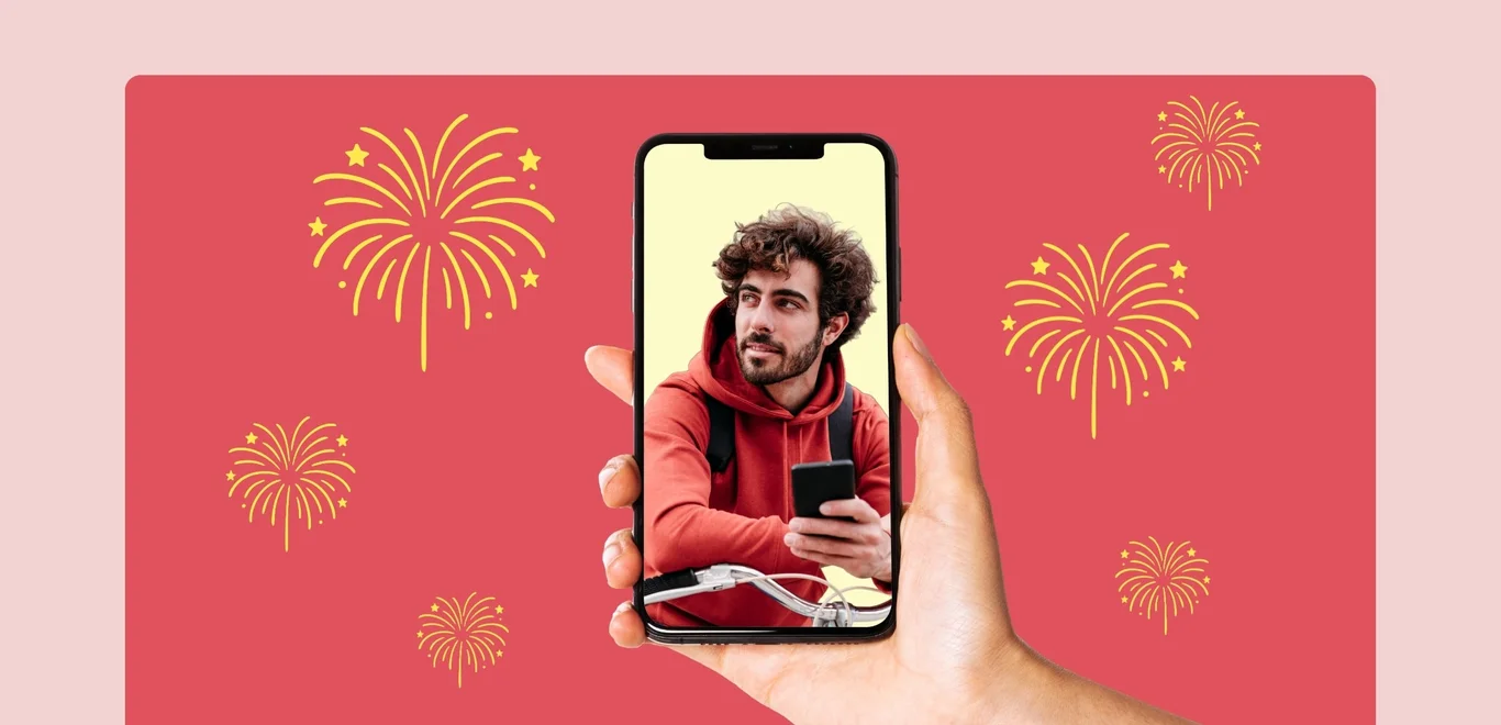 Small gold fireworks burst around a floating hand displaying a phone screen displaying a man on his phone on a medium pink rectangle against a light pink background.
